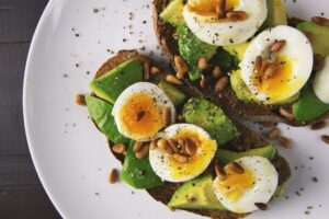 Petit déjeuner salé avec un oeuf, avocat et tartine