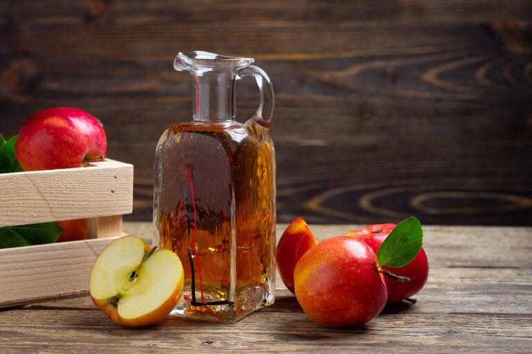 Vinaigre de cidre sur une table avec des pommes